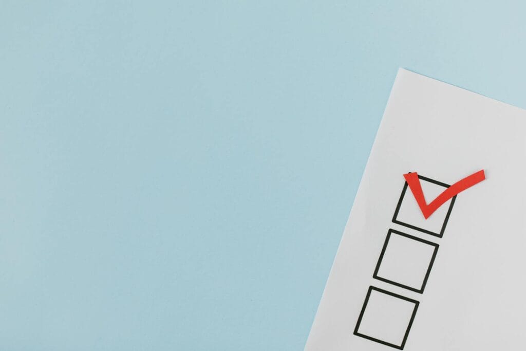 A checklist with a red checkmark symbolizing a completed task on a pastel blue background.