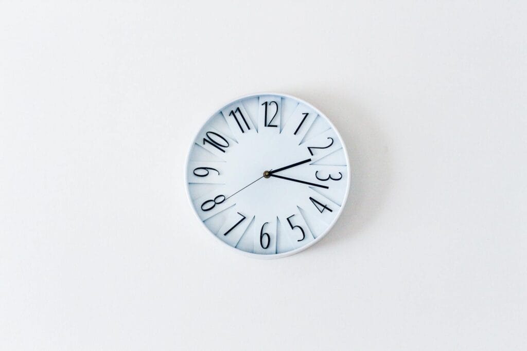 Simple minimalist wall clock on a white wall for a clean aesthetic.