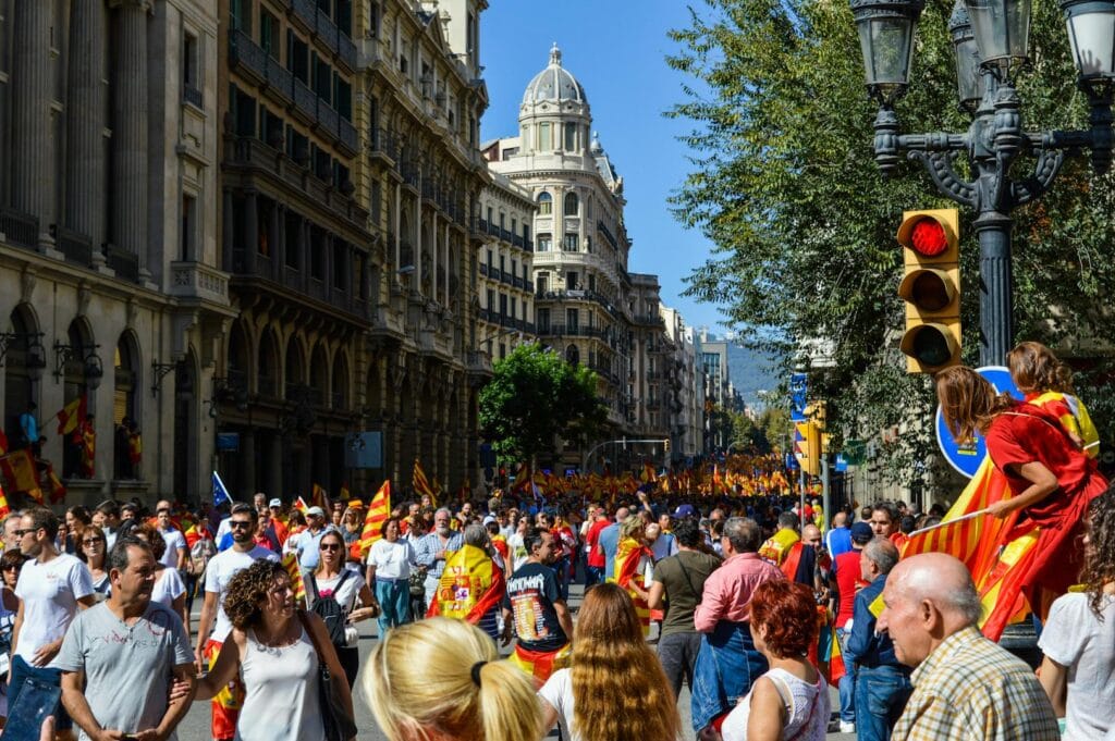 People rallying in Barcelona's streets with flags and banners, expressing unity.