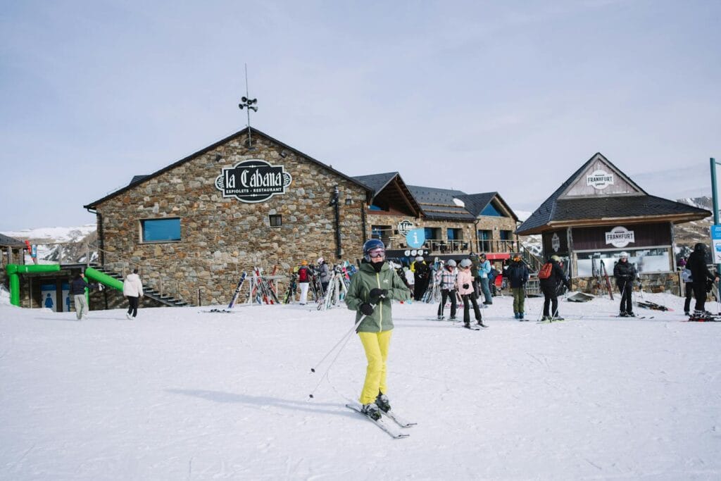 Skiers in a vibrant winter setting at La Cabaña, surrounded by snow-covered slopes and lively atmosphere.