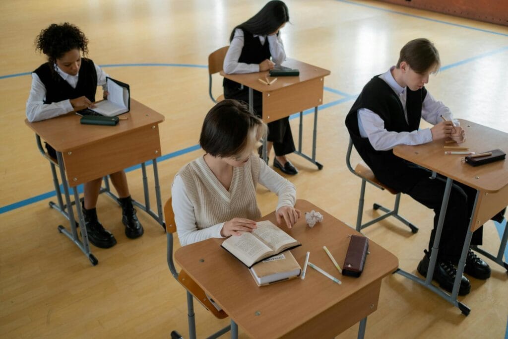 Group of diverse students studying in a well-lit indoor classroom setting.