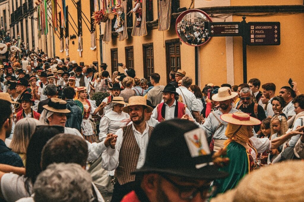 A crowd of people walking down a street next to tall buildings