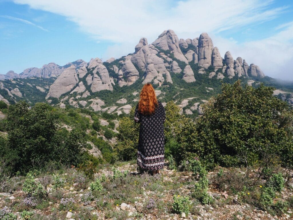 woman standing near outdoor facing on mountain range during daytime
